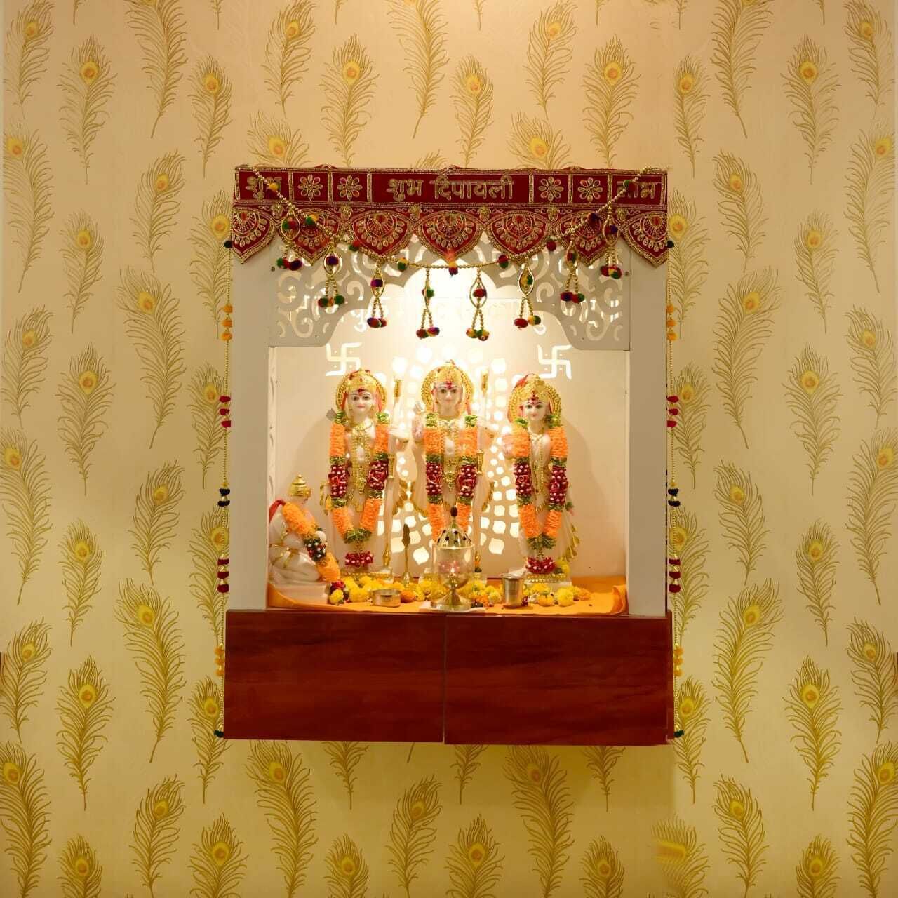 A shrine with three statues, a decorative border, and a peacock feather pattern on the wall.