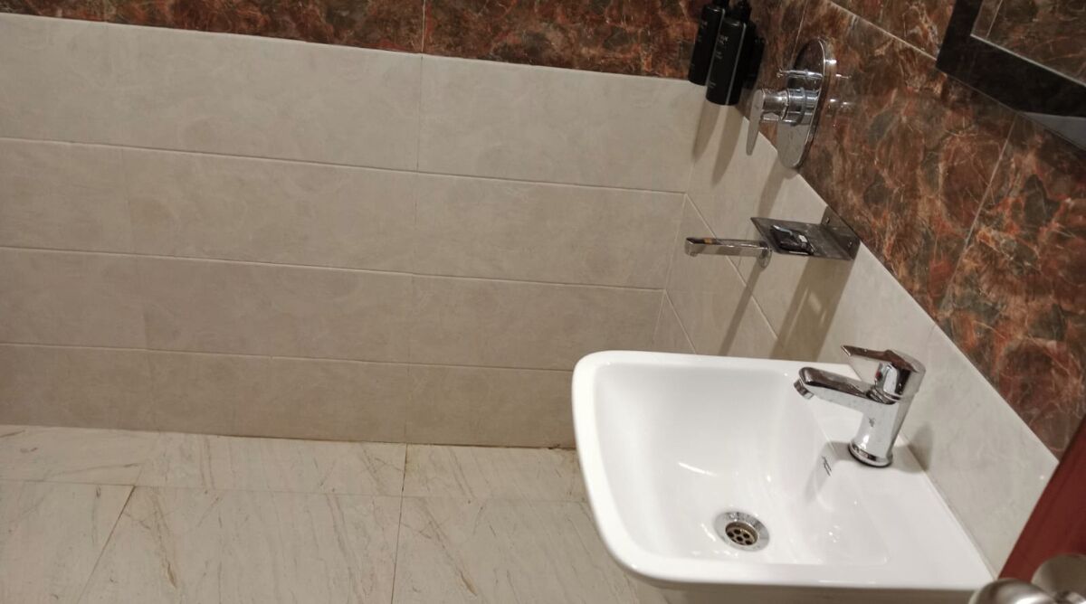 Ein Badezimmer mit Waschbecken, Spiegel und Duschbereich.