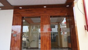 Un espace d’accueil doté d’une entrée en bois et de portes en verre.