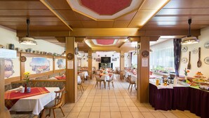 Un restaurant avec des poutres en bois, des sols carrelés et une salle à manger centrale aménagée avec des tables et des chaises.