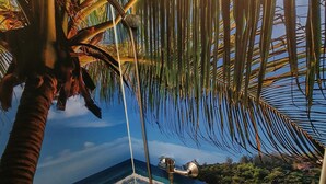 Une salle de bain avec douche, baignoire et vue sur la plage et l’océan.
