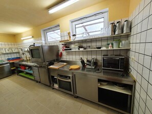 A kitchen with stainless steel appliances, a microwave, a toaster, and a window with a view.