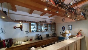 A kitchen with wooden cabinets, a countertop, a coffee machine, and a wine cooler.