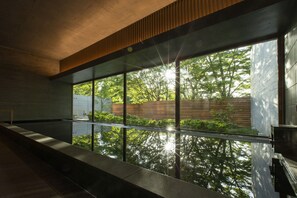 A modern interior with large windows, a concrete ceiling, and a wooden slat design. - Sport & Do Resort  RESOL NO MORI (Nagara)