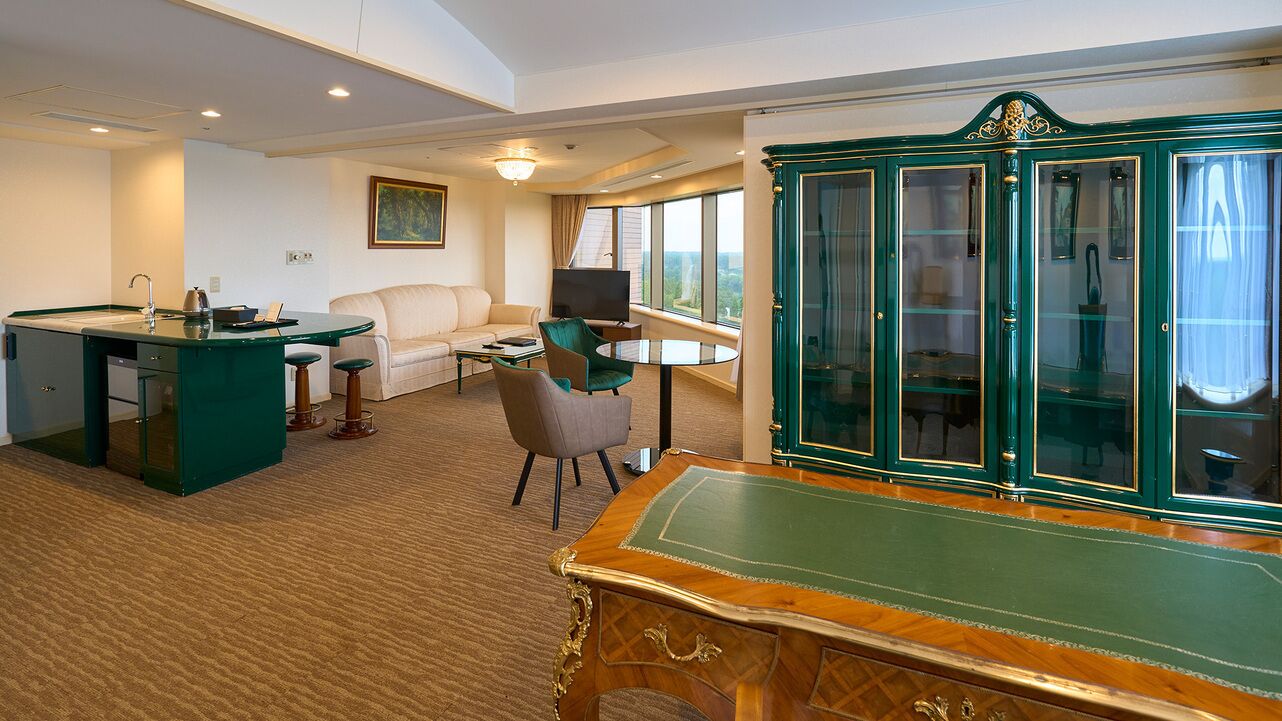 A room with a pool table, a sofa, a television, and a cabinet with glass doors.