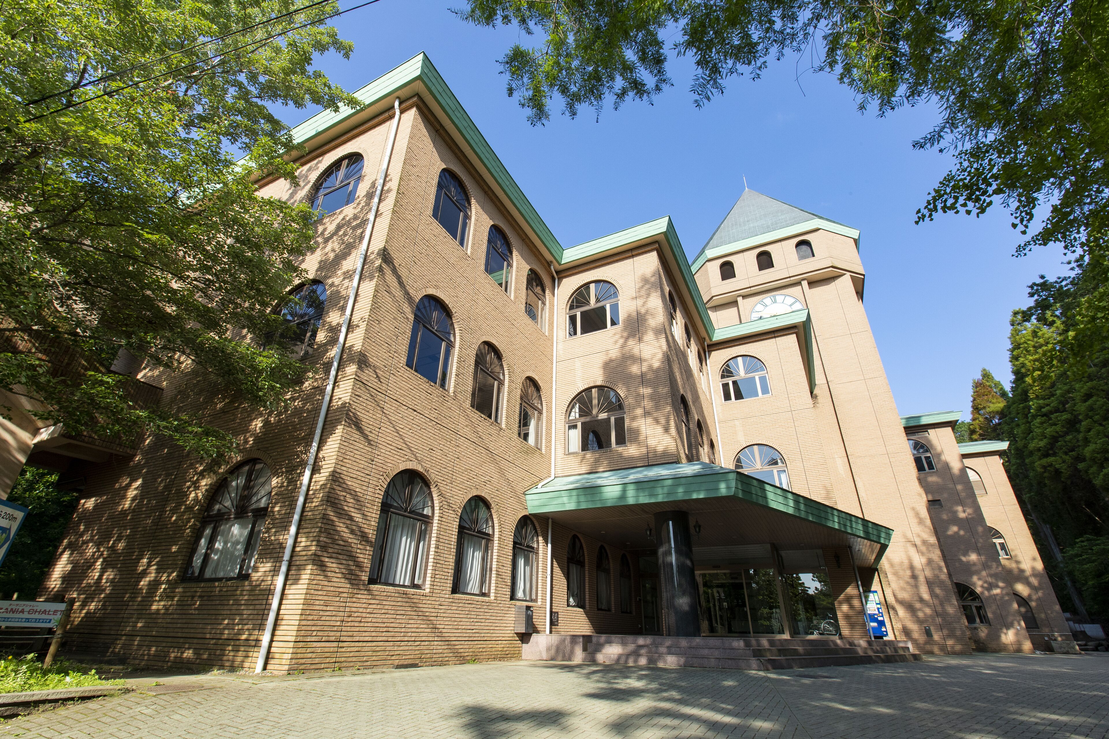 A large, multi-story building with a prominent tower and arched windows.