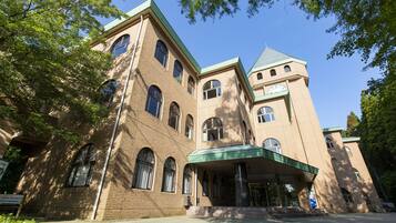 A large, multi-story building with a prominent tower and arched windows.