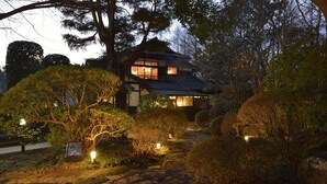A traditional Japanese house with a stone pathway leading to the entrance, surrounded by well-maintained bushes and trees. - Sport & Do Resort  RESOL NO MORI (Nagara)