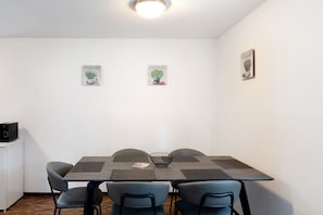 A dining area with a table, chairs, and wall art.