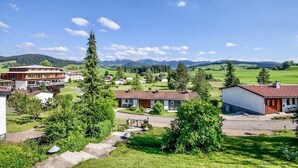 A rural village with a mix of residential and commercial buildings, including a large hotel with multiple floors and a smaller building with a red roof. - Holiday Apartment "Rommel" with Mountain View, Private Terrace & Wi-Fi (Stiefenhofen)