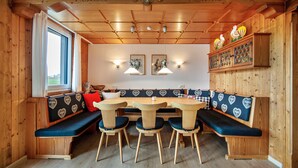 A wooden interior with a bench seating area, tables, and wall-mounted lights. - Holiday Apartment "Rommel" with Mountain View, Private Terrace & Wi-Fi (Stiefenhofen)