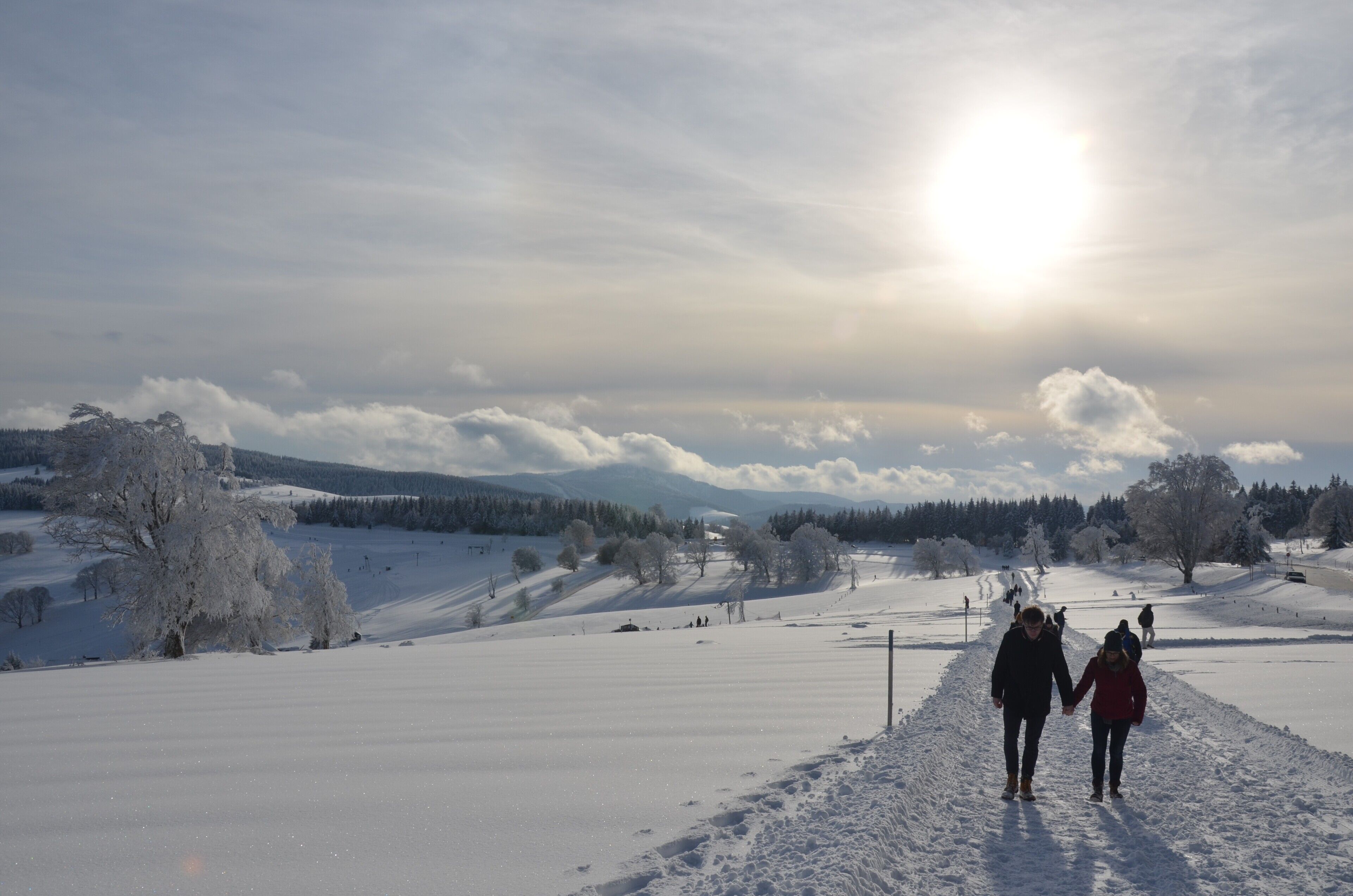 Schneebedeckte Landschaft mit blauem Himmel und fernen Bergen.