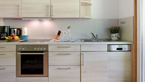 Una cucina moderna con elettrodomestici in acciaio inox, mobili in legno e un piano di lavoro in granito.