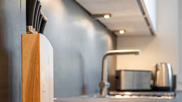 Eine moderne Küche mit einem Holz-Utensilienhalter, Edelstahlgeräten und einer eleganten Arbeitsplatte.