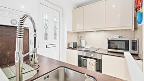 A modern kitchen with stainless steel appliances, a built-in oven, and a microwave.