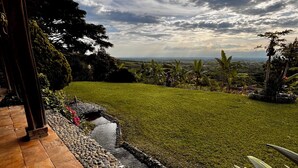 Un jardín con un sendero de piedra, una fuente pequeña y vistas al paisaje.