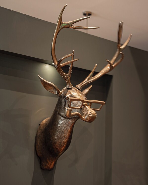 A mounted deer head sculpture with antlers. - Bed in mixed room near Coyoacan (Mexico City)