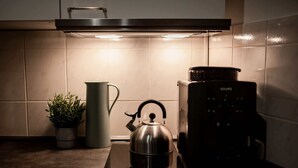 A kitchen with a kettle on a stove, a kettle on a table, and a coffee maker. - Hamburg - 3 Rooms for up to 11 guests (Hamburg)