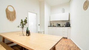 A modern kitchen with white cabinets, a wooden table, and a bench. - Hamburg - 3 Rooms for up to 11 guests (Hamburg)