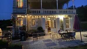 Um edifício de dois andares com varanda coberta e área para estar ao ar livre.