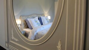 Quarto com cama, travesseiros e mesa de cabeceira com abajur.