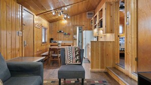Ein gemütliches Blockhaus mit Essbereich, Küche und Wohnbereich.