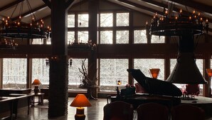 A spacious interior with large windows, a grand piano, and multiple chandeliers. - WHITE HOTEL GRAND HAKUBA (Omachi)
