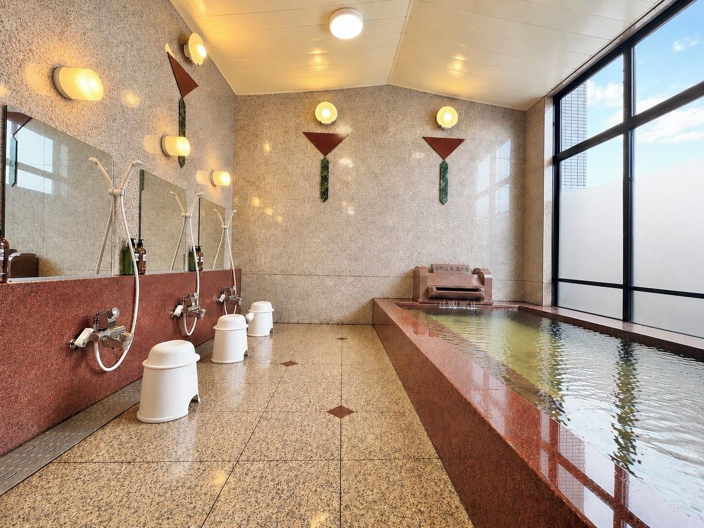 A modern bathroom with a large mirror, multiple sinks, a bathtub, and a view of the city.