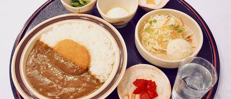 Un plateau contenant divers plats japonais, notamment du riz, de la soupe miso et des légumes marinés.