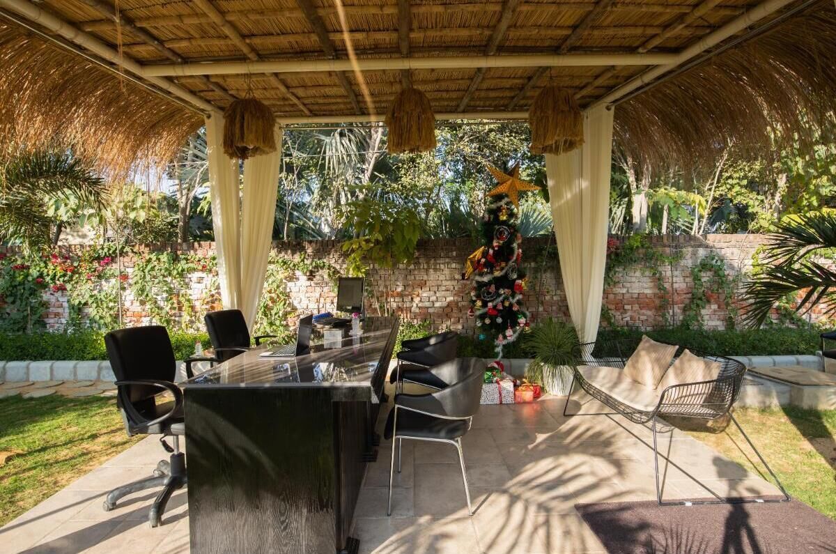 Um pátio externo com mesa de jantar, cadeiras e uma estrela decorativa.