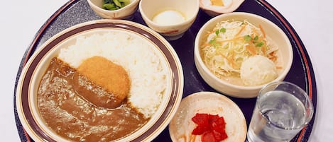 A tray with various Japanese dishes including rice, miso soup, and pickled vegetables.