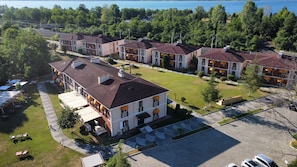A residential building complex with multiple apartment units, a parking area, and a view of a lake. - SAPANCA RESORT HOTEL (Sapanca)