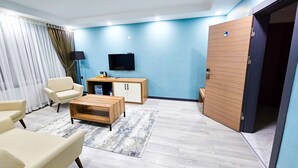 A modern living room with a sofa, a coffee table, a TV, and a cabinet. - SAPANCA RESORT HOTEL (Sapanca)
