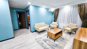 A modern living room with light wood flooring, a beige sofa set, a wooden coffee table, and a patterned rug. - SAPANCA RESORT HOTEL (Sapanca)
