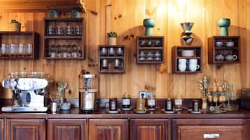 Un interior de madera con estantes que exhiben cristalería, una máquina de café y varios frascos.
