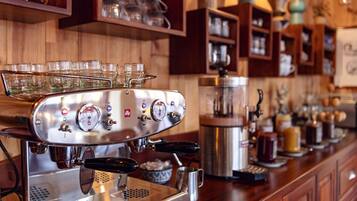 A coffee machine with multiple portafilters and a milk frothing station.
