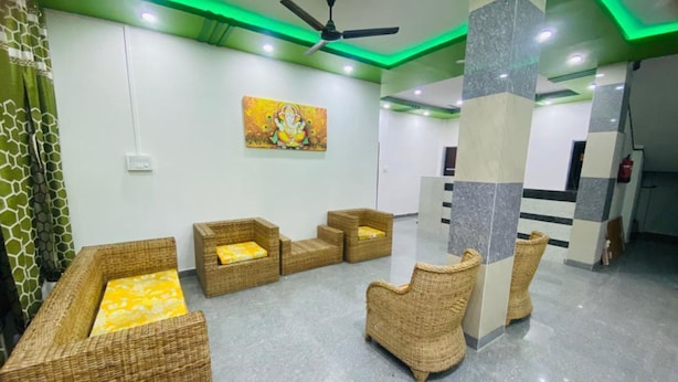 A lobby with wicker furniture, a ceiling fan, and a painting on the wall. - Kaziranga Inn (Bokakhat)