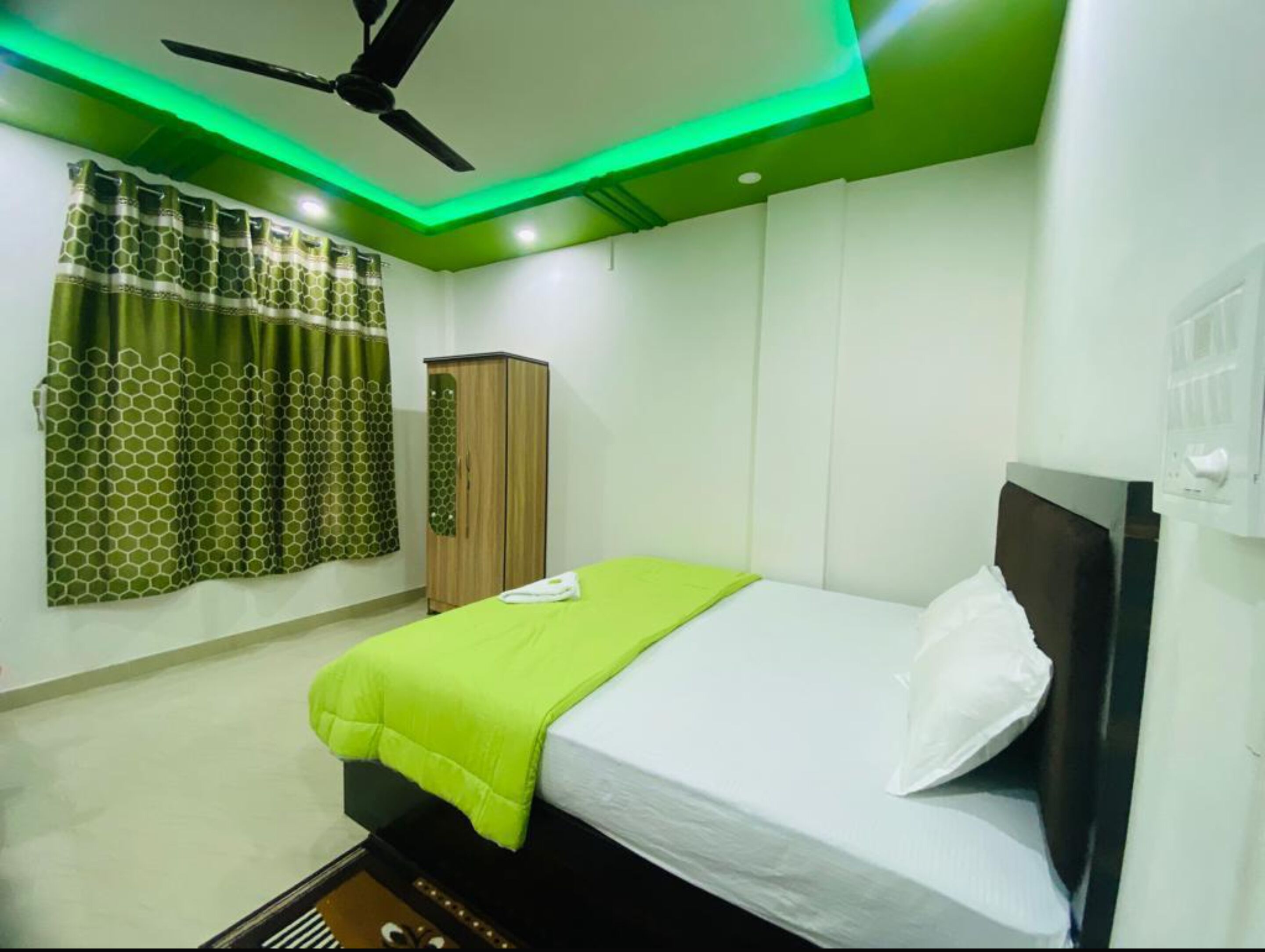 Une chambre à coucher avec un lit, une armoire et un ventilateur de plafond.