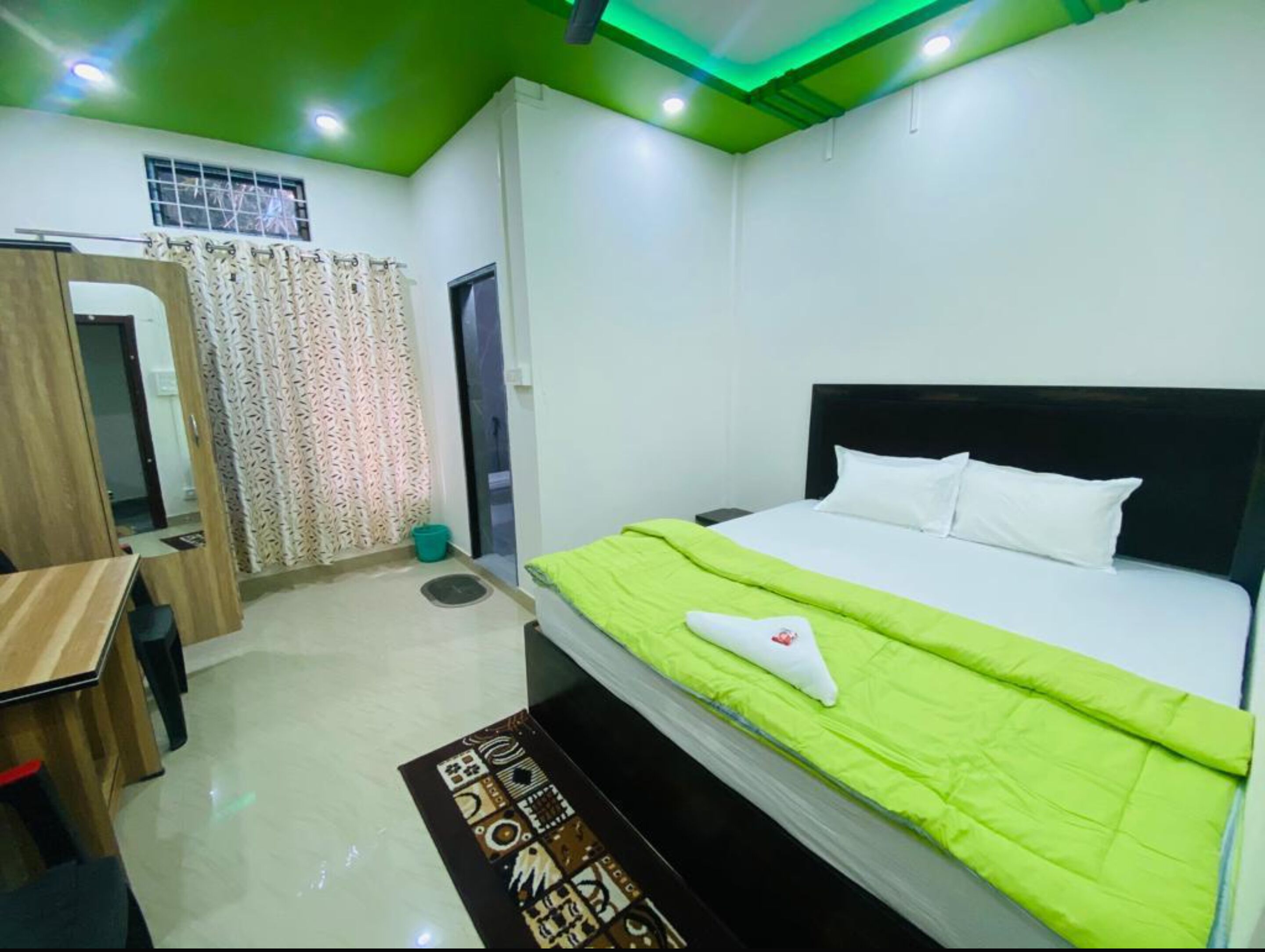 A hotel room with a bed, a desk, and a bathroom.