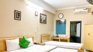A hotel room with two single beds, a wooden wardrobe, a clock, and a wall-mounted air conditioner. - Quang Chung Hotel Long Bien- Bay Luxury (Hanoi)