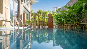 Piscina cristalina que refleja la arquitectura y la vegetación circundantes.