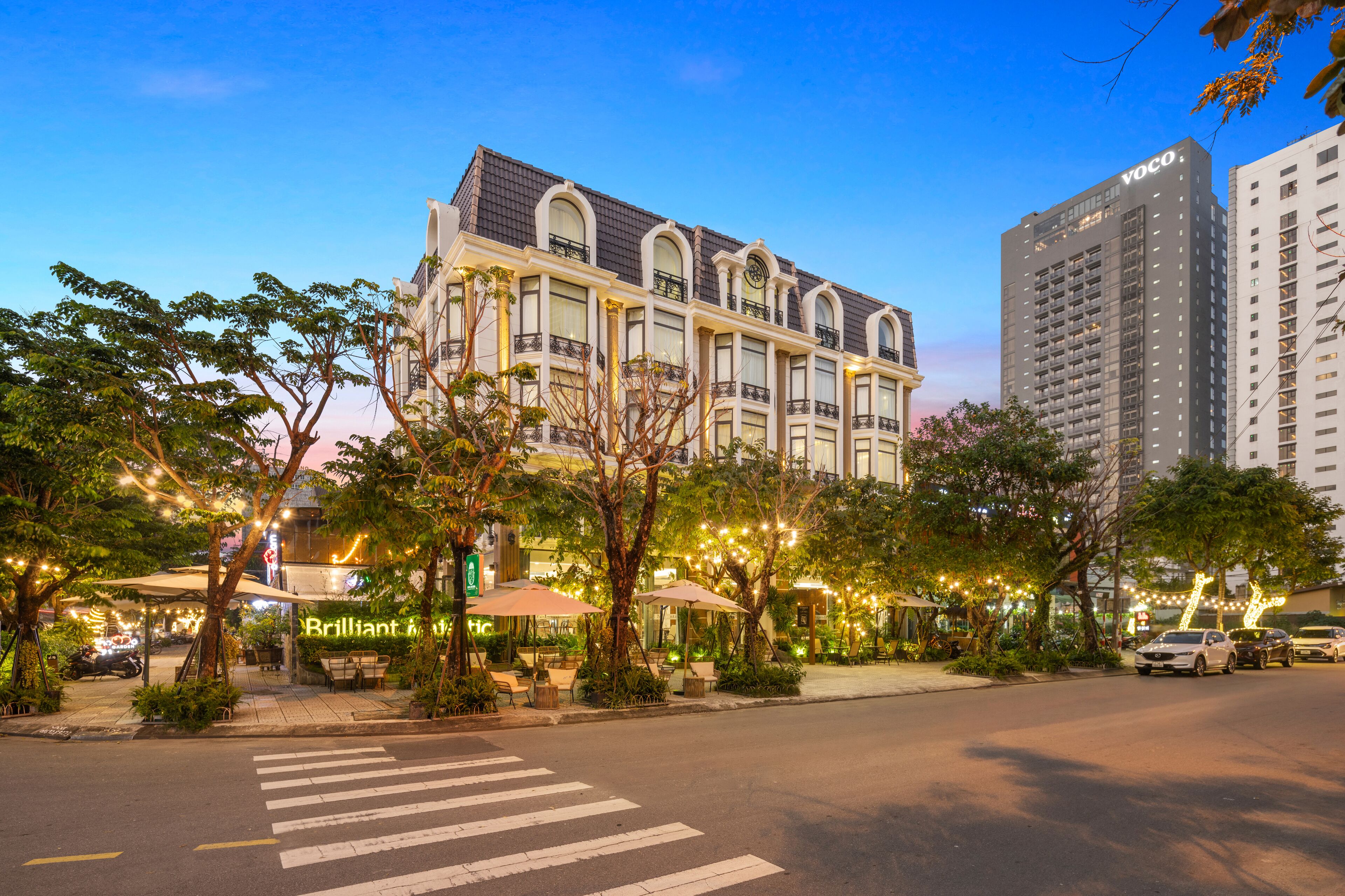 A hotel with a classic architectural style, featuring a prominent 'VOCO' sign on the building.