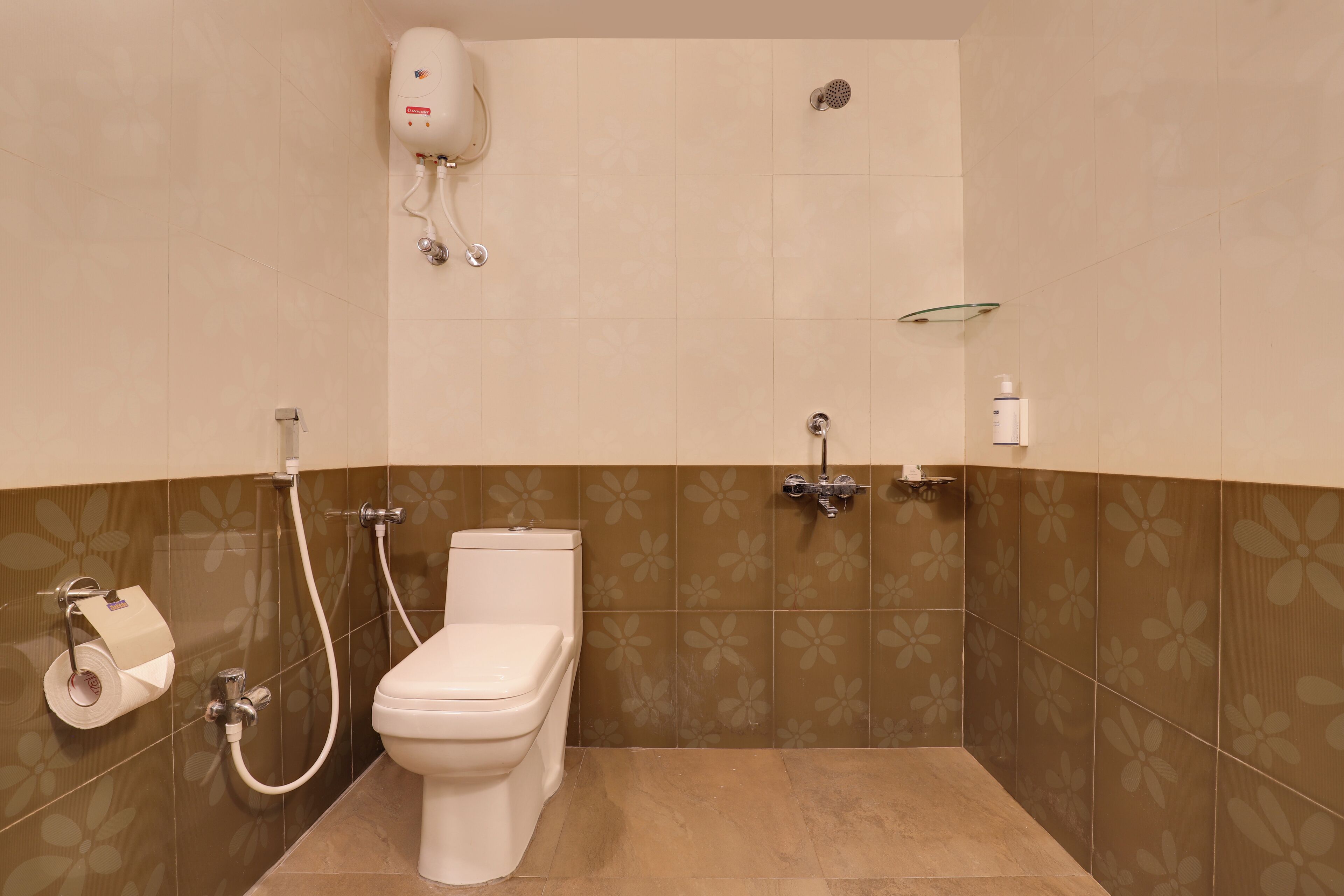 A bathroom with a toilet, a shower, and a toilet paper holder.