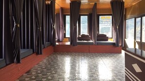 A spacious room with a tiled floor, wooden ceiling, and large windows with curtains. - Scenic Views Farmstay & Hostel (Sa Pa)