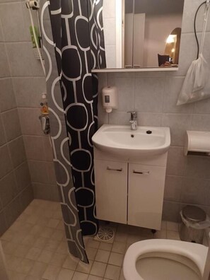 Een douche, een haardroger, pantoffels, handdoeken
