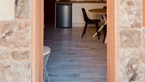 A stone-framed doorway leading into a modern kitchen with a dining area. - Click & Guest - Casa Mama Carina B (Agüimes)