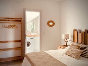 1 dormitorio y tabla de planchar con plancha