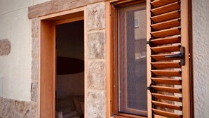 A stone building with a wooden door and window with shutters. - Click & Guest - Casa Mama Carina B (Agüimes)