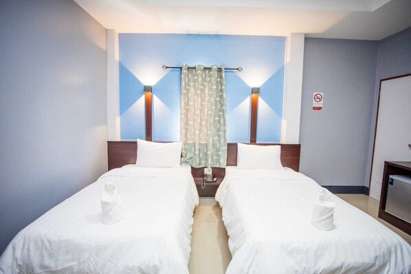 Une chambre d’hôtel avec deux lits, une douche et un téléviseur.