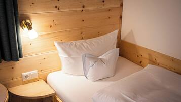 Habitació de disseny de cabana de fusta, amb llit, tauleta de nit i làmpada penjada a la paret.